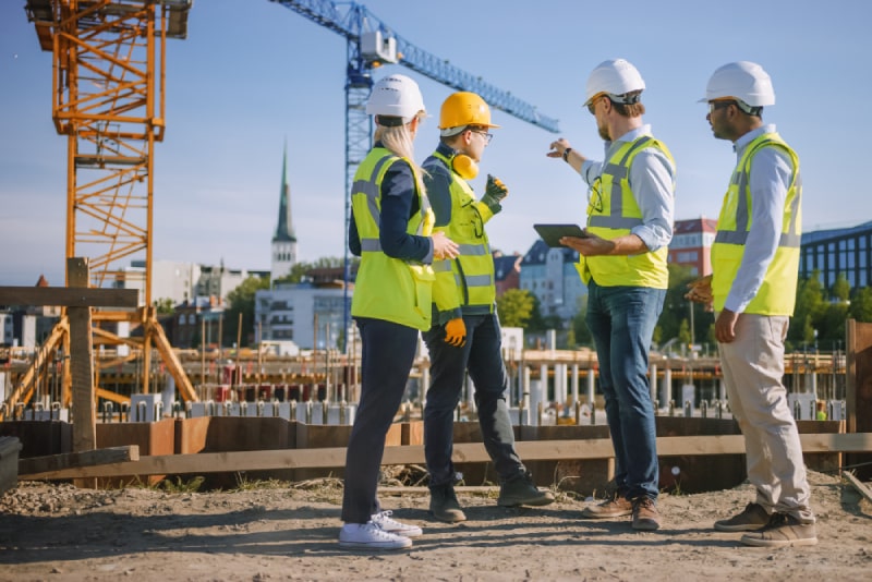 small group of employees siting around table discussing work